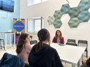 Interno della sala rinnovata per la attivtà Galattica nel nodo, Roll up con logo galattica e persone sedute attorno ad un tavolo