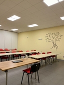 Sala con tavoli e sedie, disegno di un albero sul muro