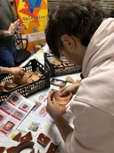 Gruppo di persone che lavorano su un progetto a un tavolo con pezzi di ceramica.