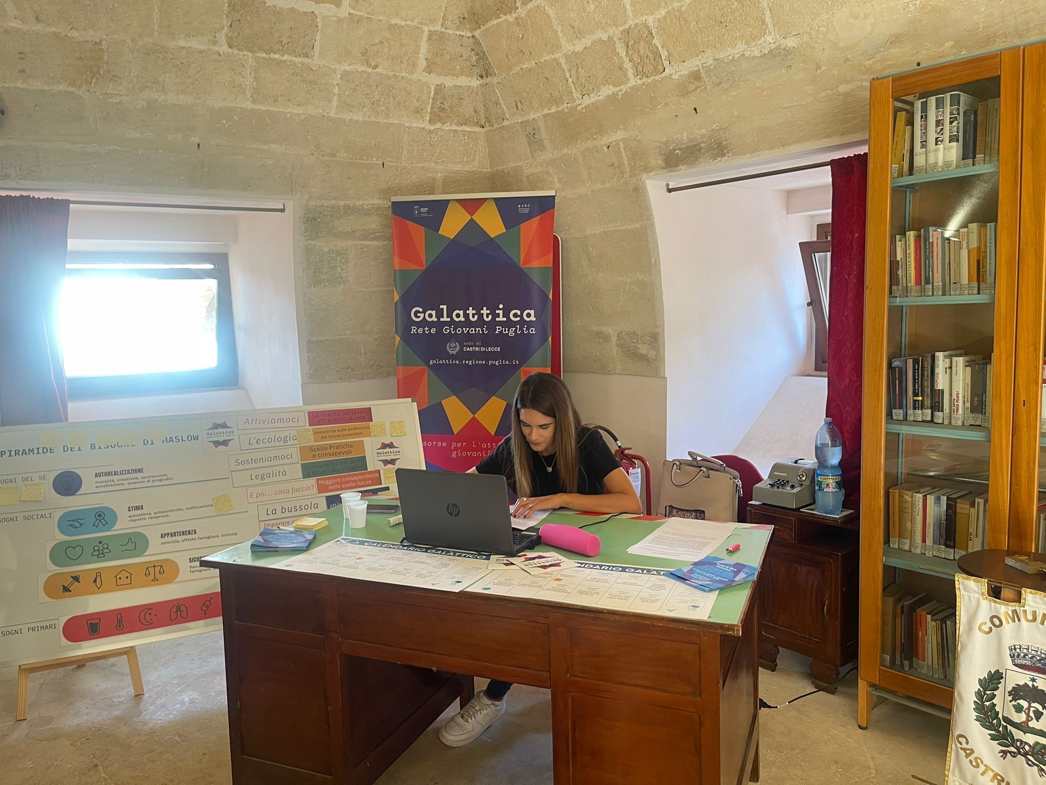 Sportello "Galattica" a Castrì. Foto di una donna che lavora al computer seduta alla scrivania.