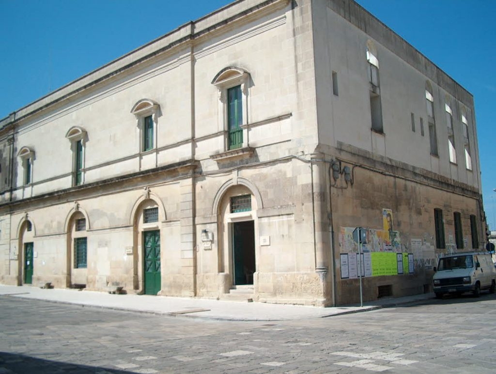 Edificio storico color sabbia con finestre verdi