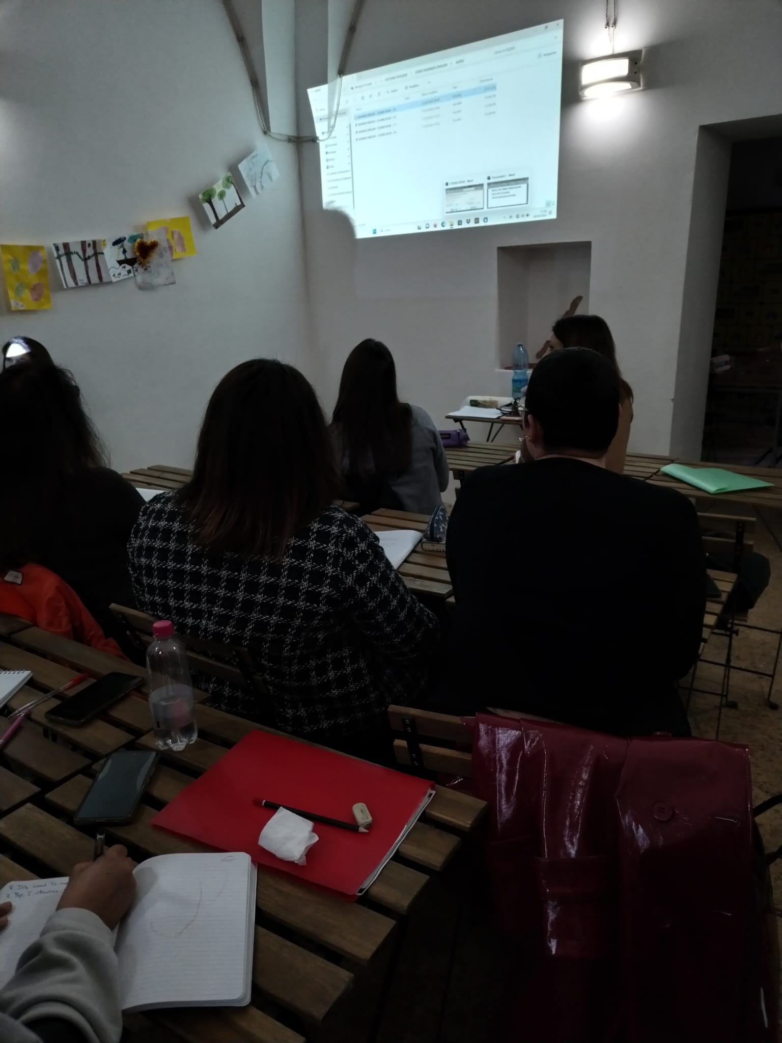 Un gruppo di persone in una sala guarda una presentazion