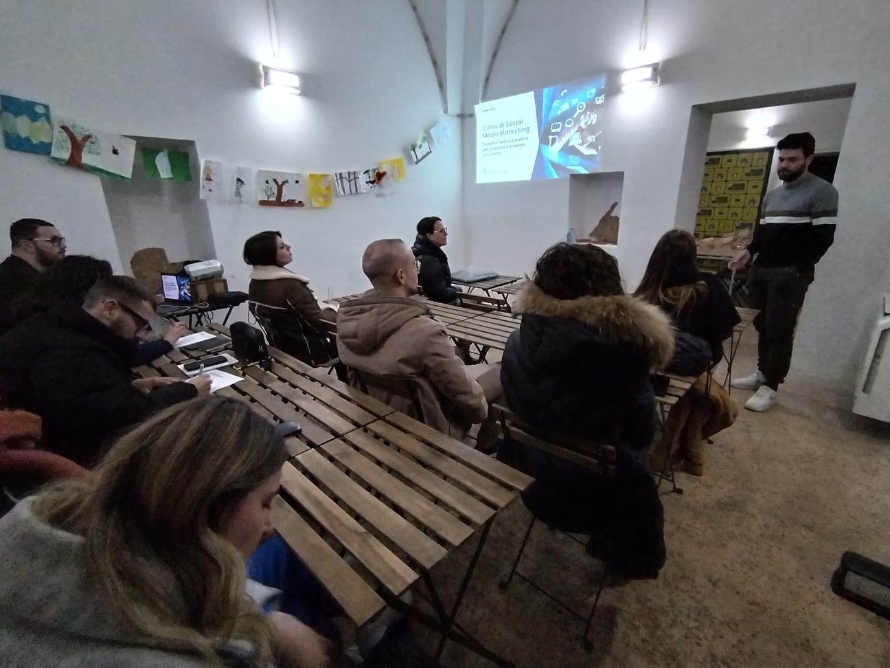 Un gruppo di persone in una sala guarda una presentazione