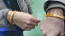 Primo piano dei gadget di Galattica, due braccialetti in plastica con la scritta "Galattica" sul polso di due persone presenti all'evento di Inaugurazione del Nodo Galattica di Cisternino, 18 novembre 2023