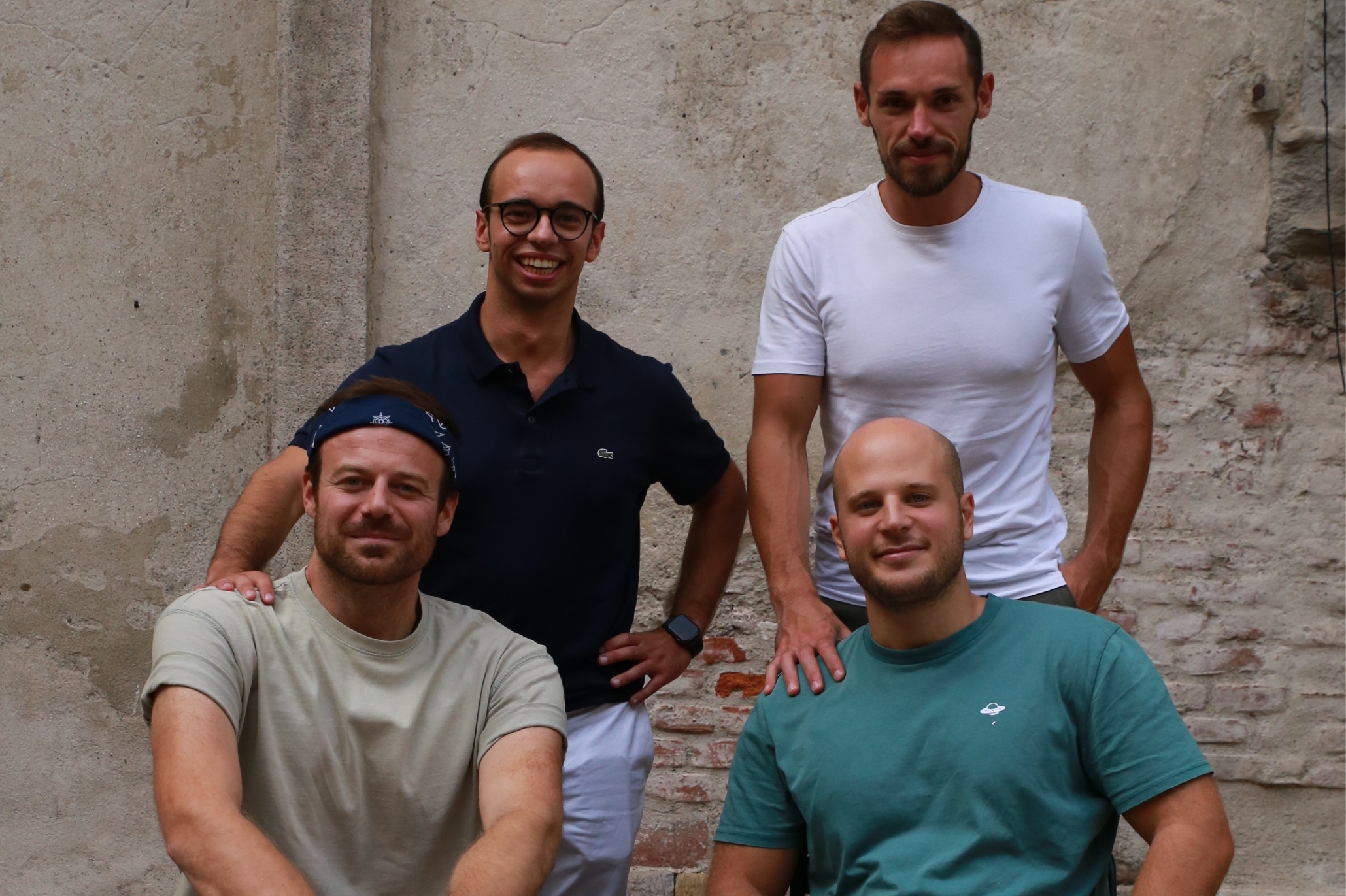 Quattro ragazzi sorridenti in posa per una fotografia di gruppo