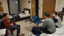 Tre membri del Team Remate discutono davanti a un laptop durante una riunione serale in una camera d’hotelIl Team Remate si dedica a una sessione di lavoro serale in hotel, confrontandosi sulle strategie per il progetto Future Innovators