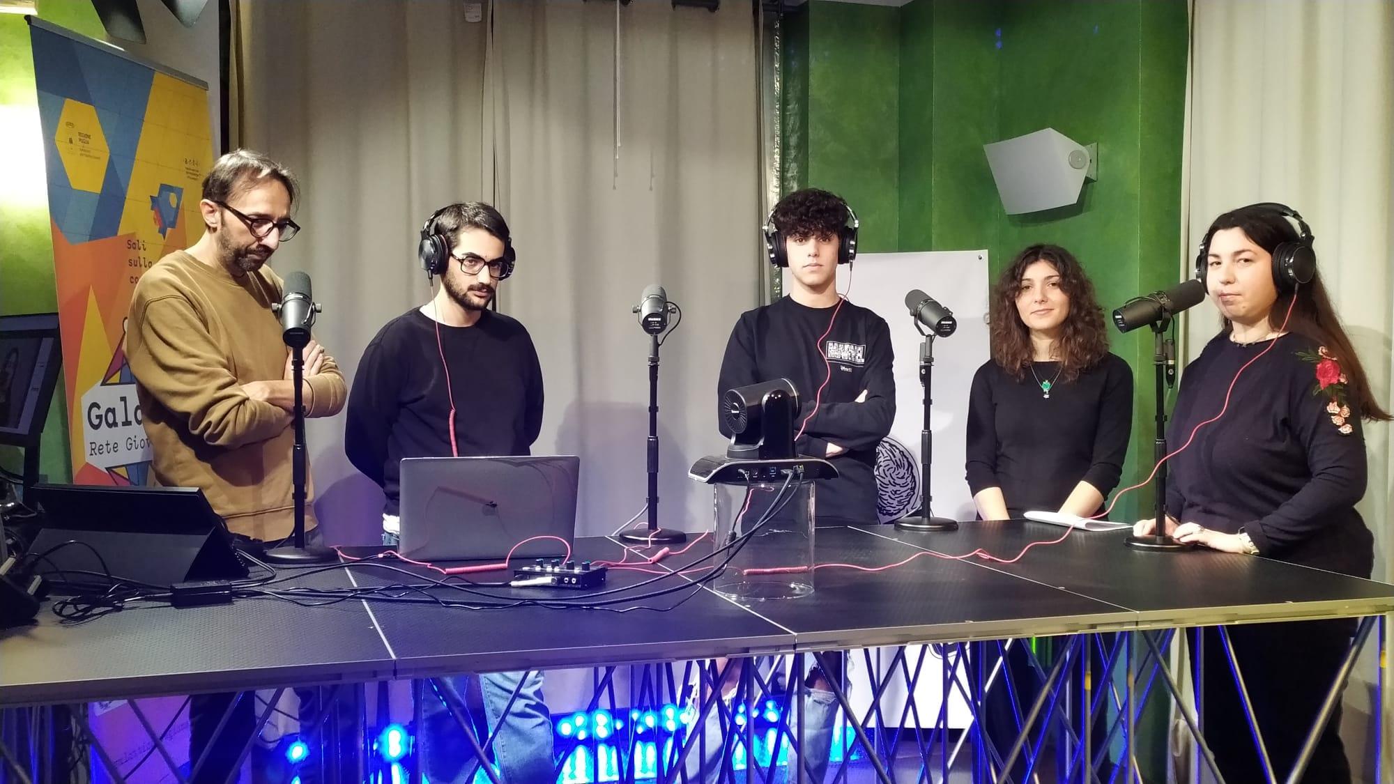 Gruppo di giovani con cuffie in postazione radiofonica