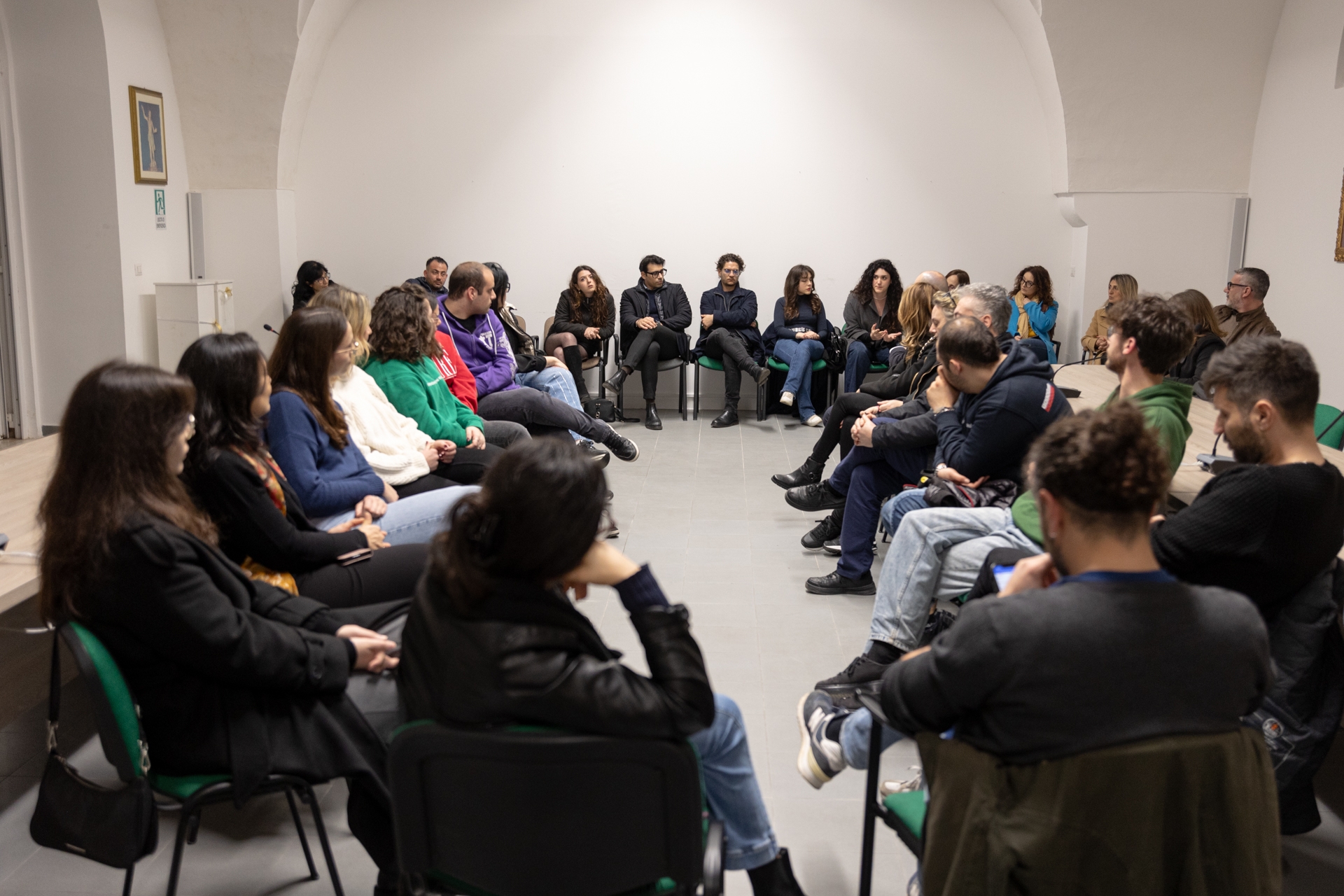 Un gruppo di persone sedute in cerchio in una stanza