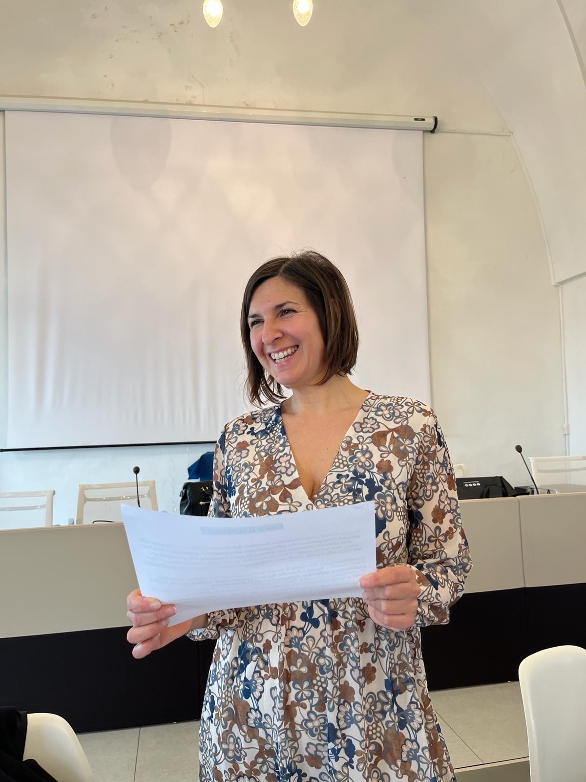 Persona che ride con un foglio in mano durante il Laboratorio di Tecniche di Gestione B&B presso il Nodo di Ceglie Messapica