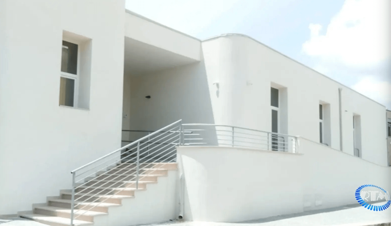 1. Imponente edificio bianco di oltre 700 metri quadrati e collocato su due livelli, uno seminterrato e uno rialzato. Nella foto è possibile notare una scalinata e un’ampia rampa di superamento delle barriere architettoniche per poter accedere all’interno della struttura.