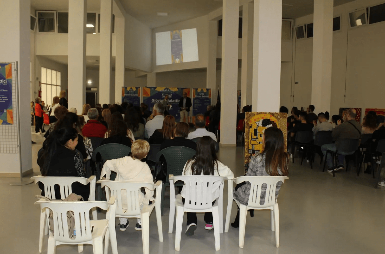5. Pubblico che segue attentamente, in un’ampia sala, l’evento di lancio.