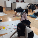 Laboratorio Bodyscape per giovani ragazzi Ragazzi stesi a terra davanti a cartelloni bianchi e colorati