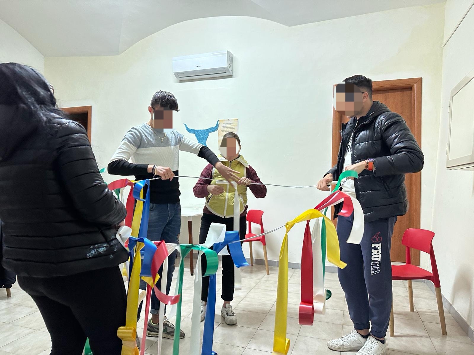 4 ragazzi di cui due ragazzi e una ragazza che tengono alcune stogge colorate in una stanza con le pareti chiare