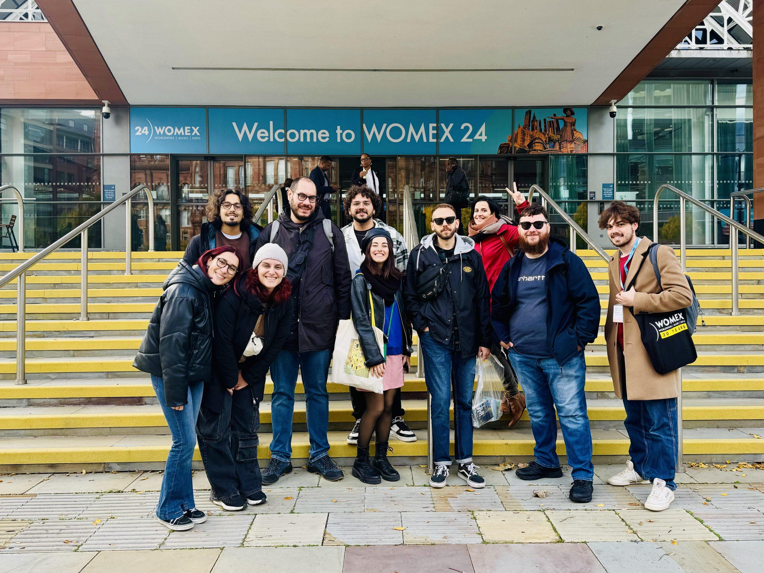 Team Radio Luoghi Comuni davanti all’ingresso del Womex 2024 Il team di Radio Luoghi Comuni davanti all'ingresso del Womex 2024